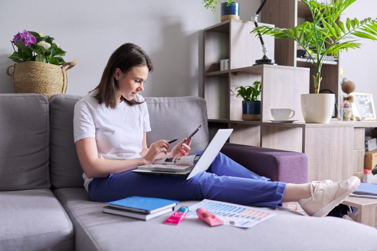 Mulher empreendedora criando catálogo de produtos digital no celular e notebook para vender online com organização e praticidade.