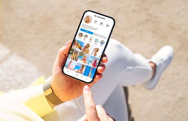 Pessoa segurando celular com perfil do Instagram aberto, exemplo visual de organização para criar posts que vendem no Instagram.