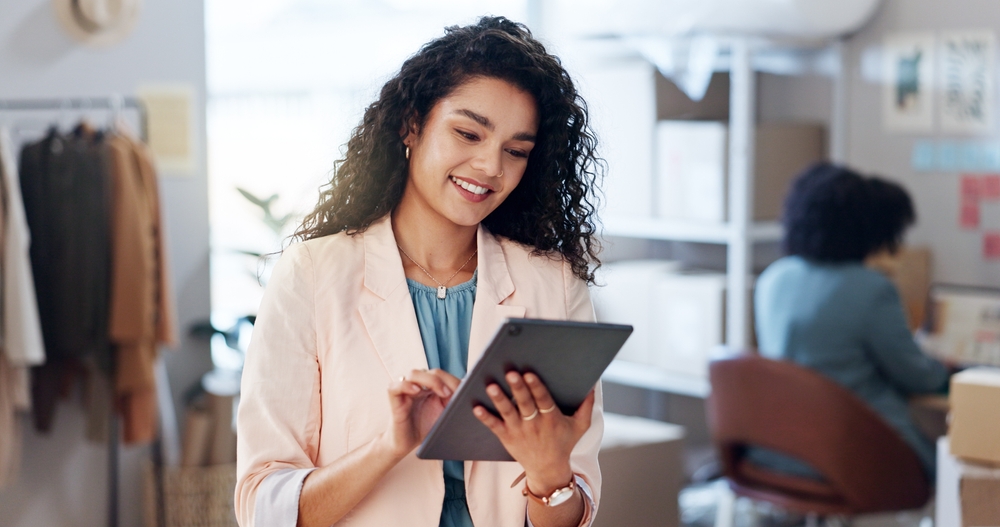 Empreendedora organizando o negócio pelo tablet em ambiente de trabalho